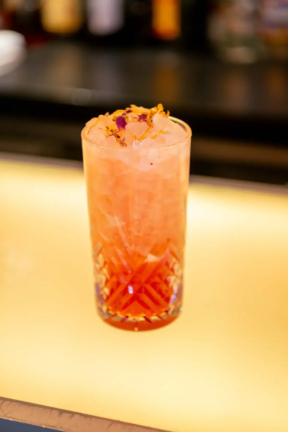 Cocktail maison orangé servi sur le comptoir lumineux du bar de Chez Pont-Pont