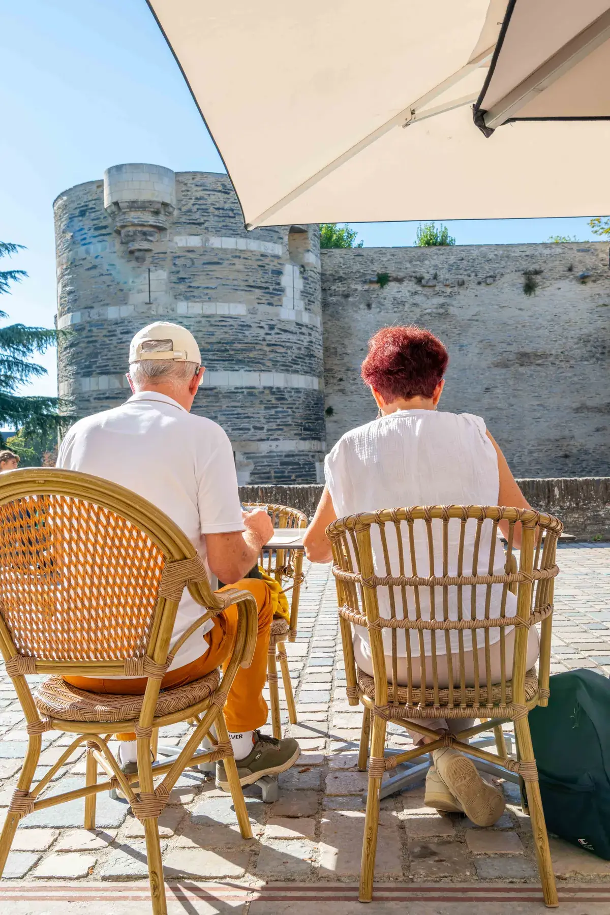 Couple installé sur la terrasse de Chez Pont-Pont, face au château d’Angers