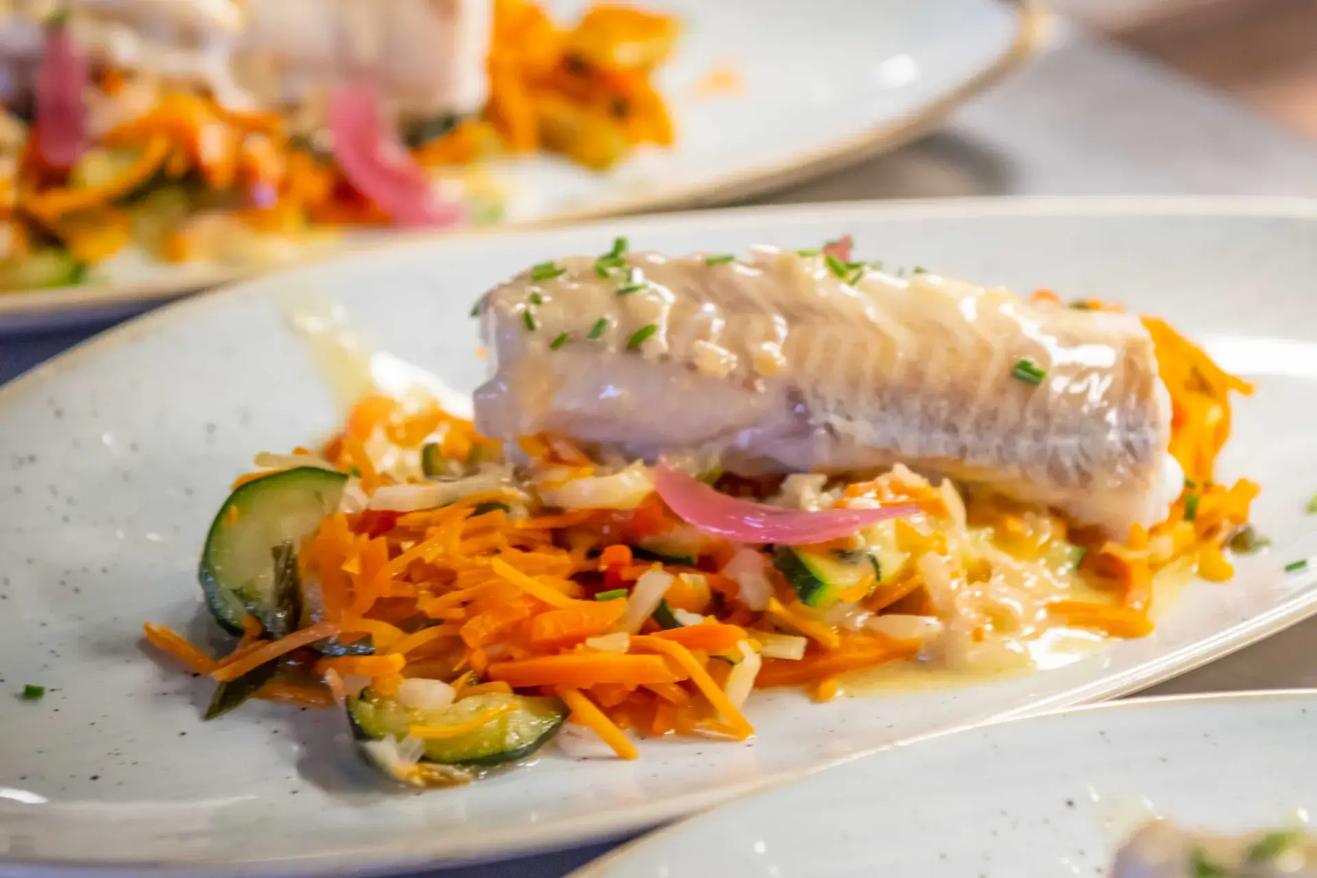 Filet de poisson et légumes croquants dressés à l’assiette au restaurant Chez Pont-Pont