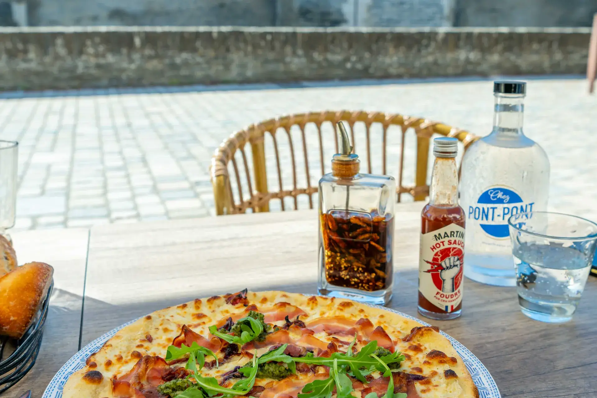 Pizza à la roquette sur la table de la terrasse, face au château d’Angers