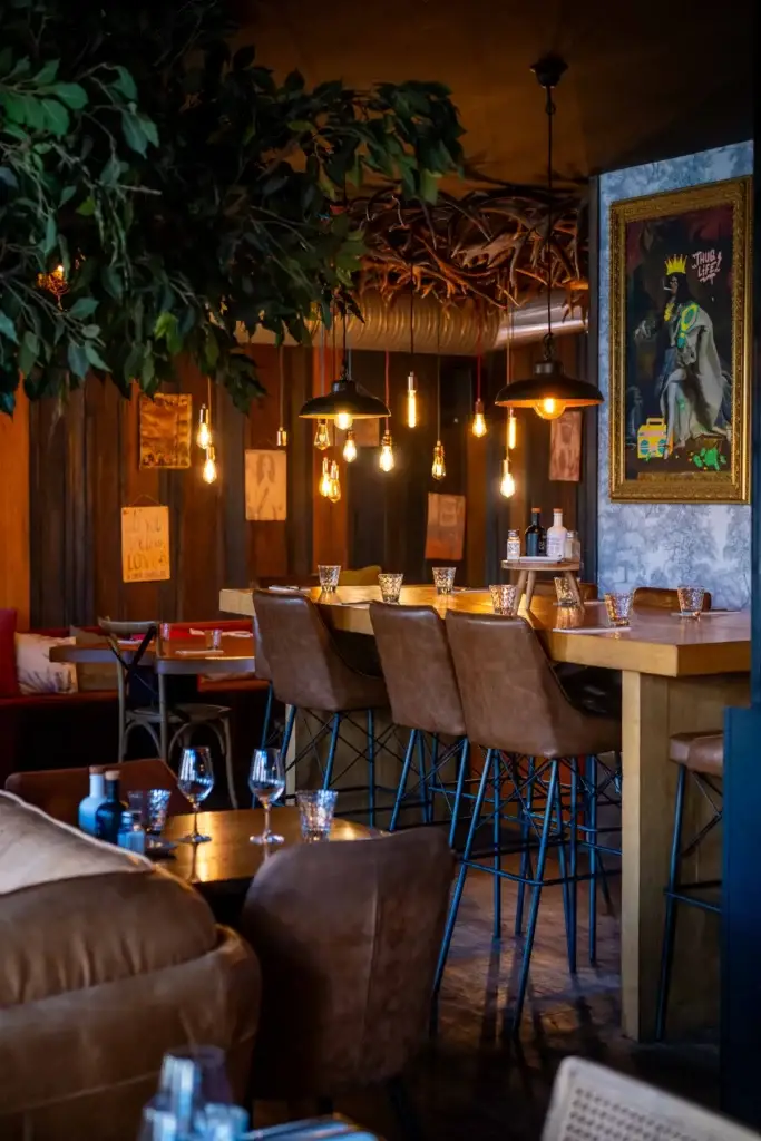Salle chaleureuse du bar-restaurant Chez Pont-Pont, banquettes en cuir et suspensions lumineuses