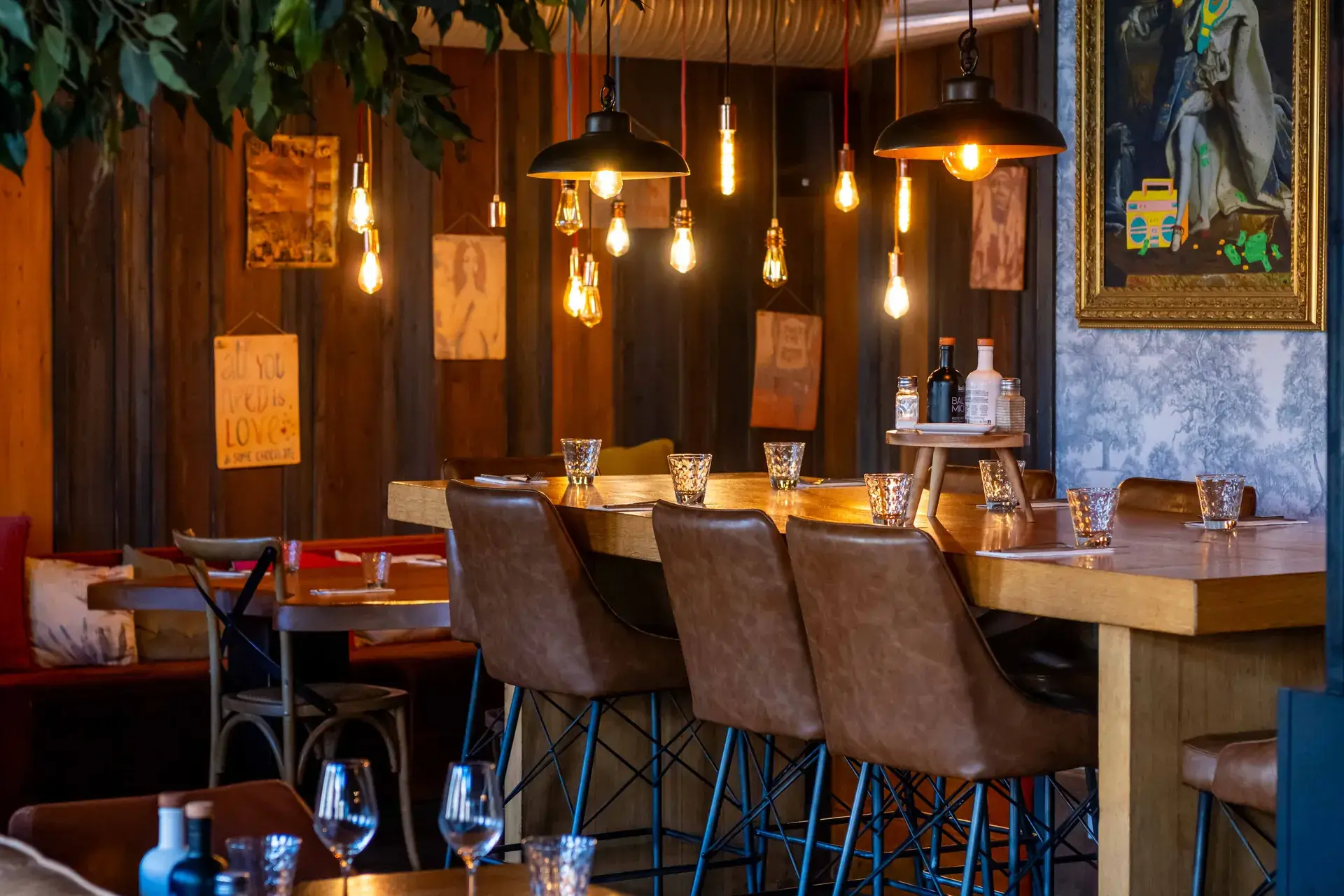 Salle chaleureuse du bar-restaurant Chez Pont-Pont, banquettes en cuir et suspensions lumineuses