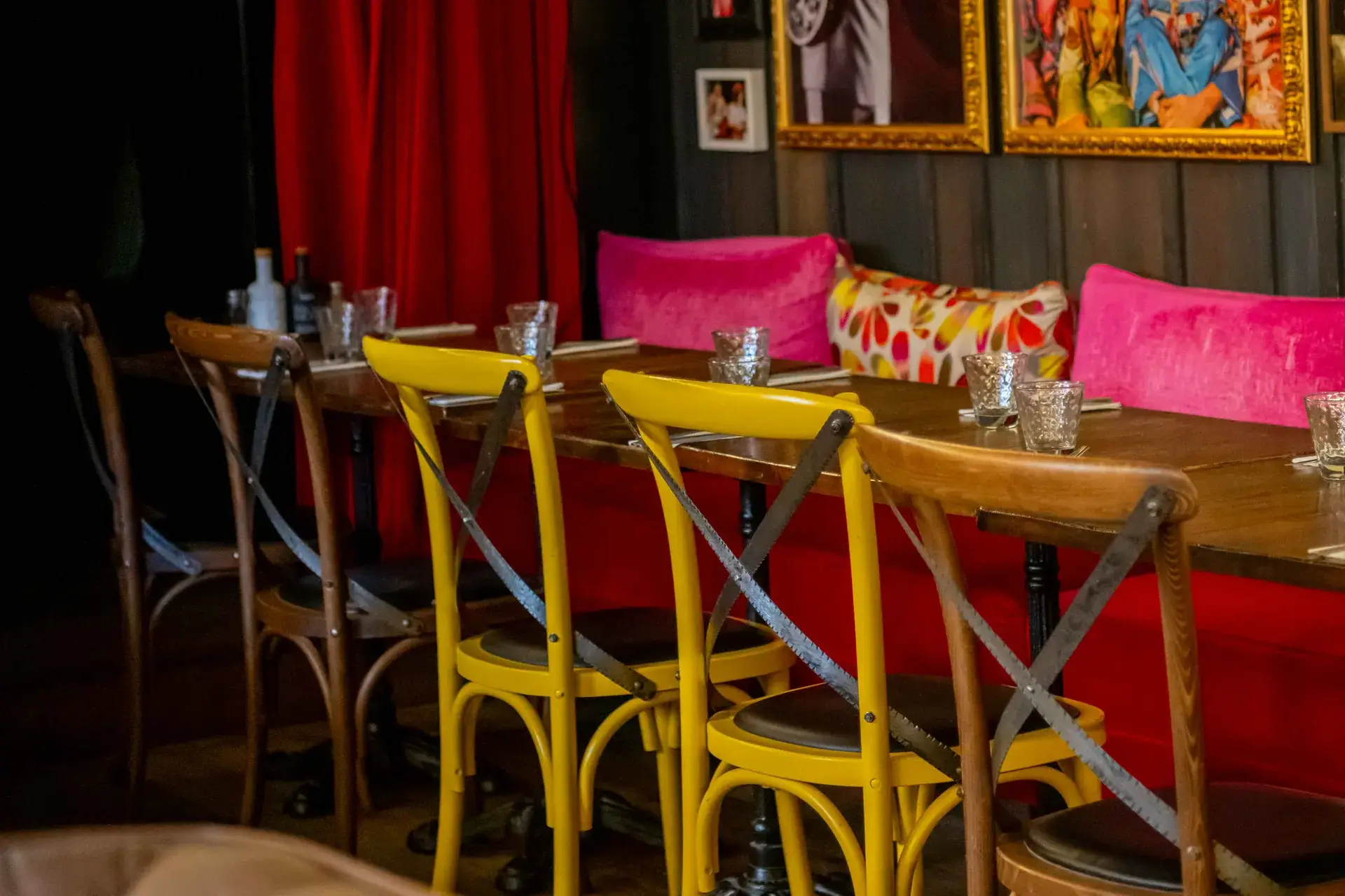 Salle privatisable de Chez Pont-Pont, décor de cadres rock, rideau rouge et chaises jaunes