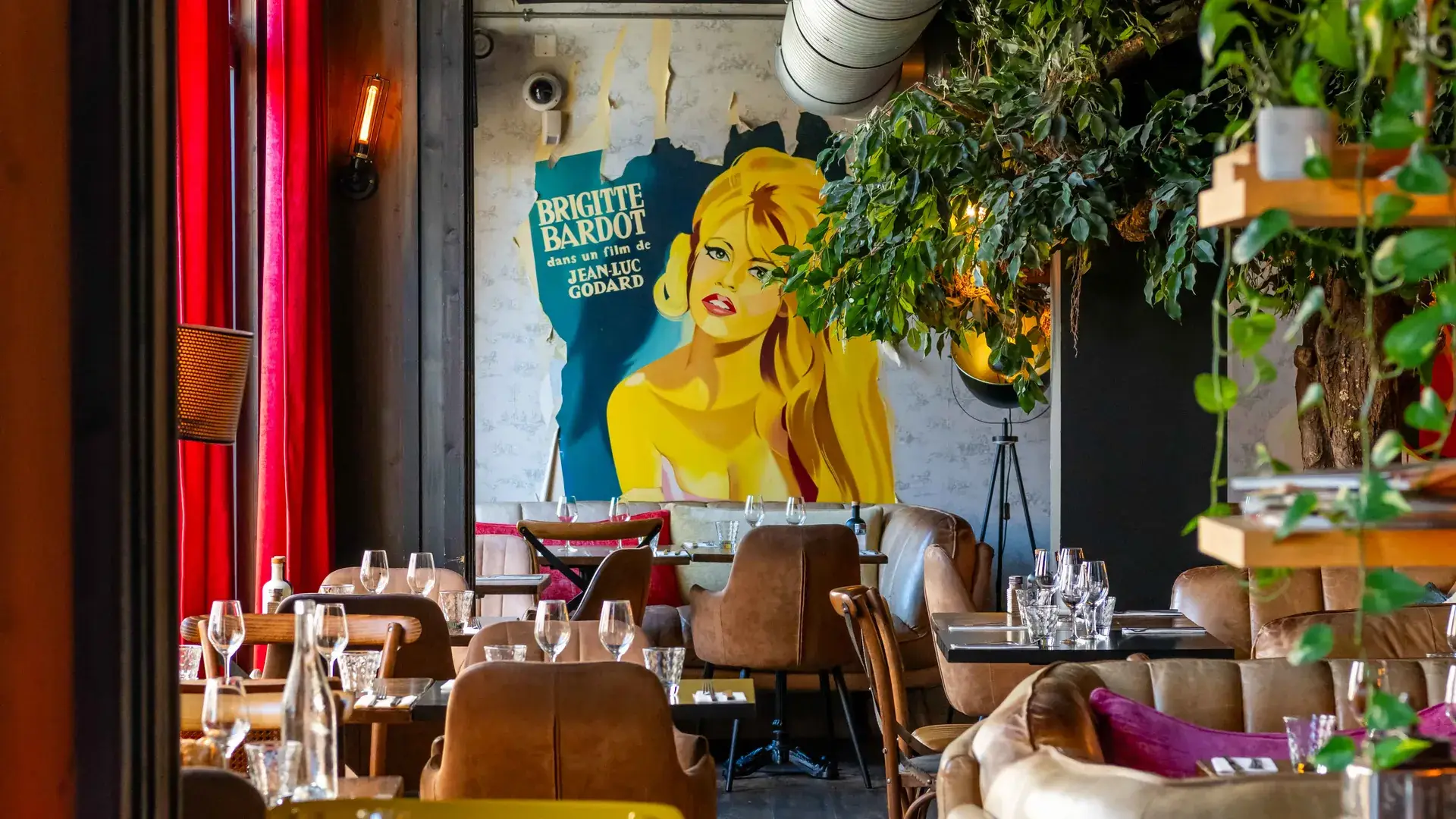 Salle du restaurant Chez Pont-Pont à Angers, avec fresque pop-art, plantes vertes et chaises jaunes