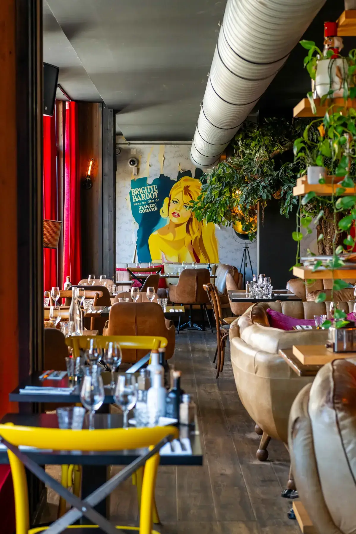 Salle du restaurant Chez Pont-Pont à Angers, avec fresque pop-art, plantes vertes et chaises jaunes