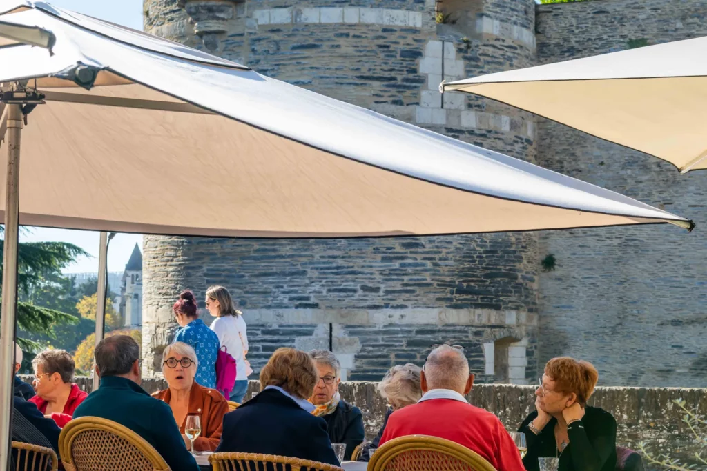 Terrasse ensoleillée du restaurant Chez Pont-Pont, sous les parasols face au château d’Angers